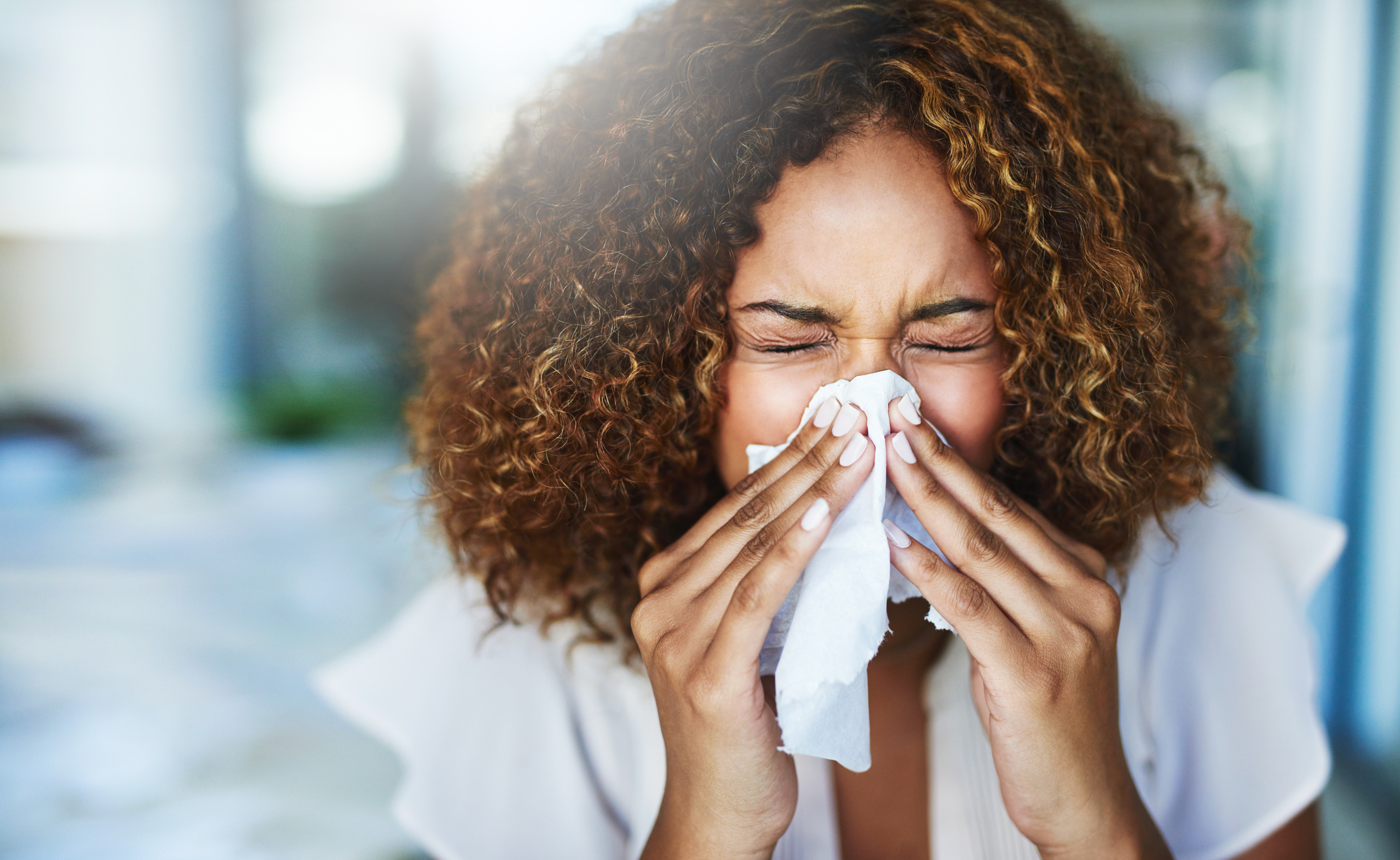 Woman blowing her nose with tissue