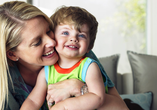 Smiling Mom holding adorable child